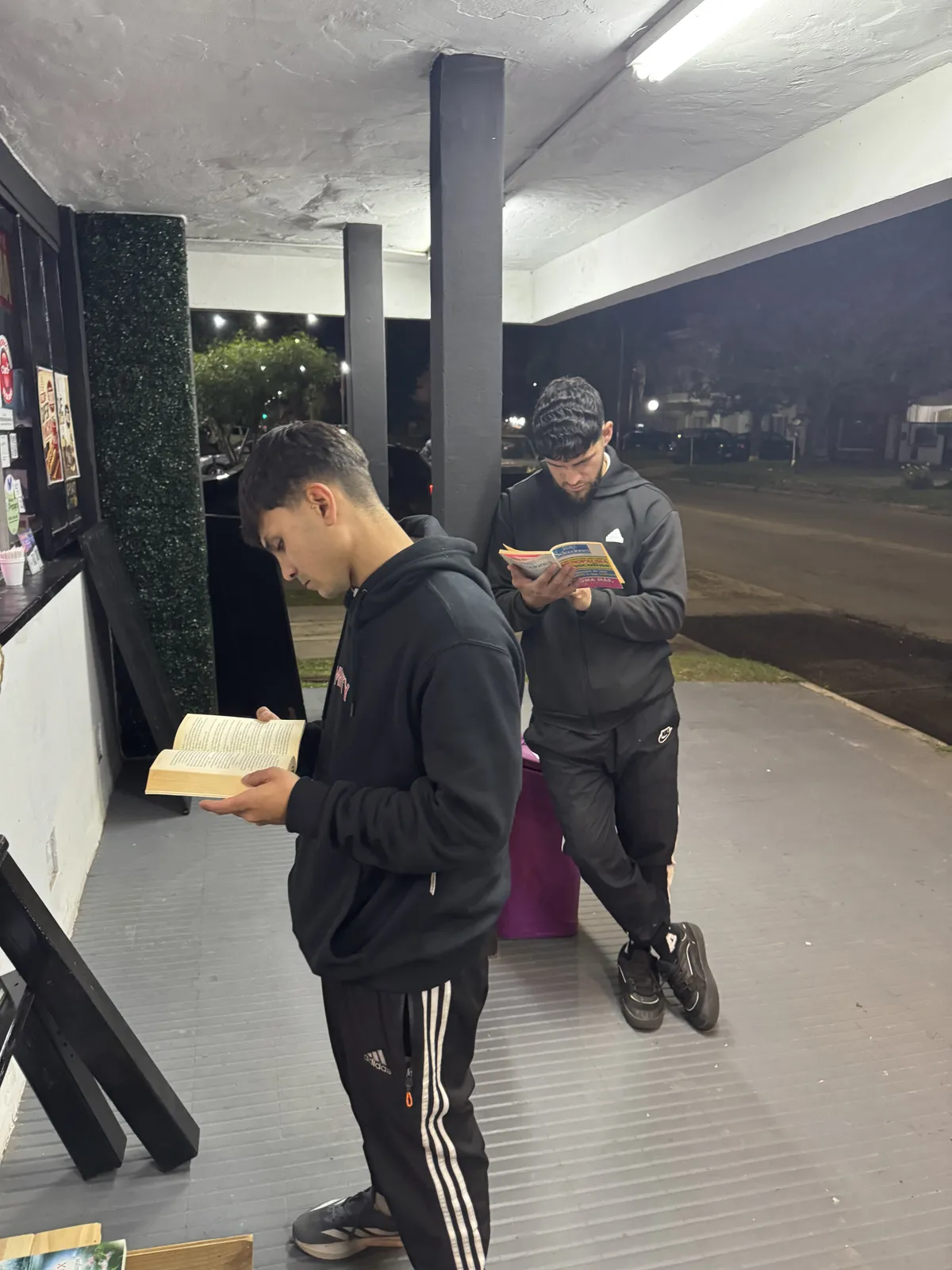 Lectores hojeando libros bajo las luces del local