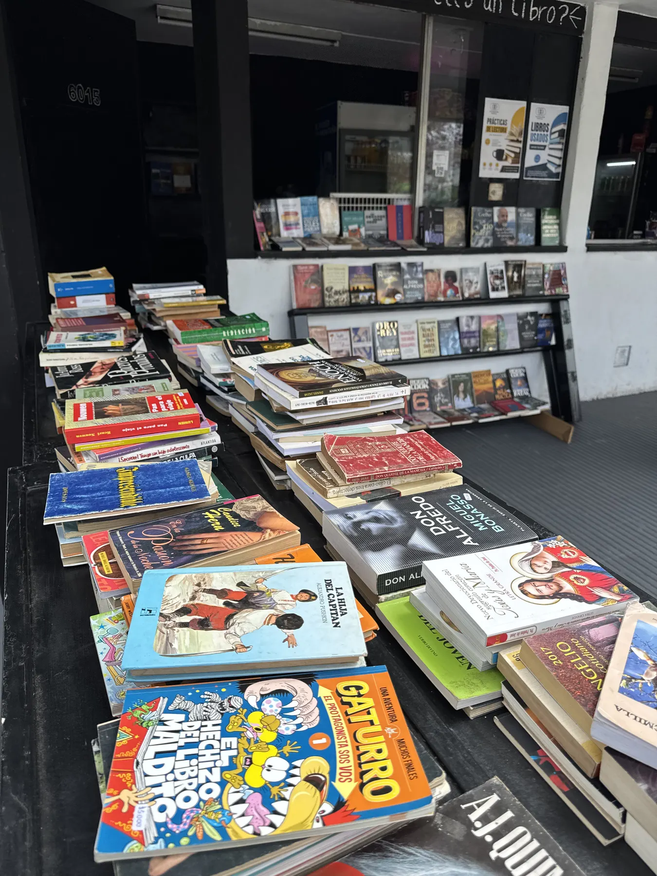 Mesa con libros usados apilados en la vereda del local